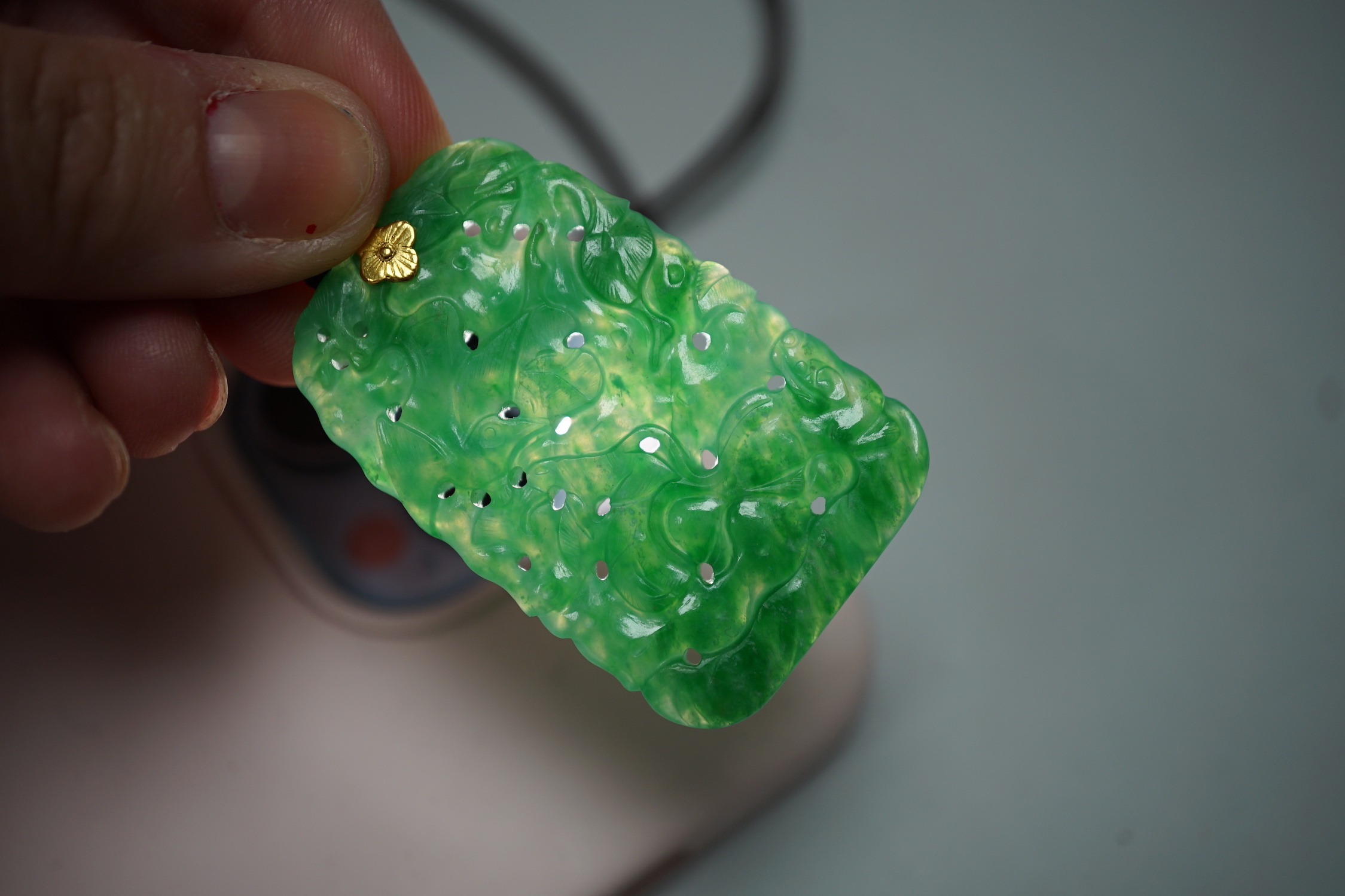 A carved Chinese jadeite pendant with pierced decoration. 5.5 x 3cm